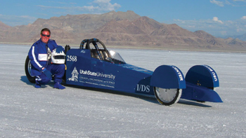 at utah's bonneville salt flats, usu biochemist michael r. morgan poses beside the 'aggie a-salt streamliner,’ a usu-built dragster powered with usu-developed biodiesel the undergrad drove to a land speed record.