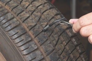 while the cement is still wet, push the wire puller through the injury from the inside of the tire. grasping the wire, use a steady pull until ½-inch of the gray rubber on the plug is exposed outside the tire.